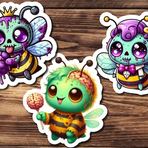 May include: Three cute cartoon bee stickers with zombie-like features. The bees are green, purple, and blue with dripping goo and candy. The bees are wearing a crown, a bow tie, and a brain lollipop.