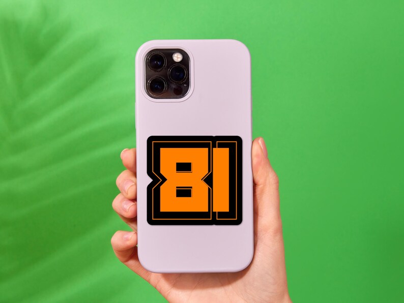 May include: A white phone case with a black and orange sticker that says "81" on it.