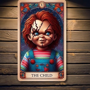 May include: A tarot card with a colorful border and a red-haired doll with stitches and a striped shirt. The card is labeled "The Child" and has the number "3" in the top right corner.