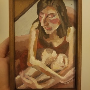 May include: Oil painting in a wooden frame. The artwork depicts a woman in a red dress holding a child. The woman has dark hair and rosy cheeks. The painting is signed in the lower right corner.