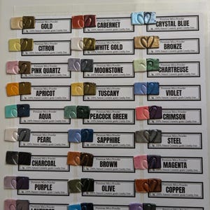 Black and white polymer clay tiles are arranged next to the color of mica powder used to create the metallic, pearlescent or colorful effect.