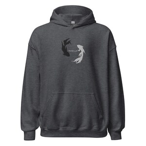 May include: A dark heather grey hoodie with a black and white fish design and the text "The world is my sea".