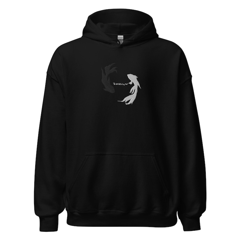 May include: Black hoodie with a white and black fish design on the front. The fish are swimming in a circle, facing each other.