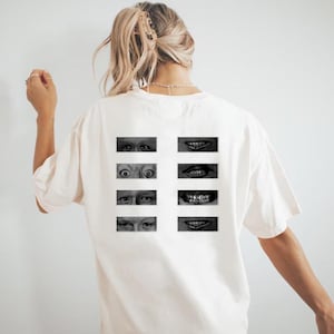 May include: Off-white t-shirt with a grid of black and white images of eyes and mouths. The images are arranged in two columns of four, creating a unique and artistic design. The shirt is a casual, oversized style.