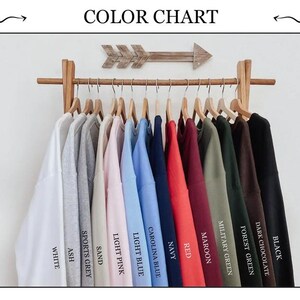 May include: Color chart showing 12 different sweatshirt colors, including white, ash, sports grey, sand, light pink, light blue, carolina blue, navy, red, maroon, military green, forest green, and dark chocolate.