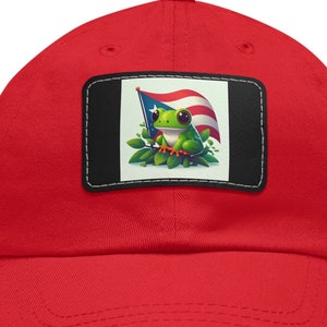 May include: Red baseball cap with a patch featuring a green frog holding a Puerto Rican flag.
