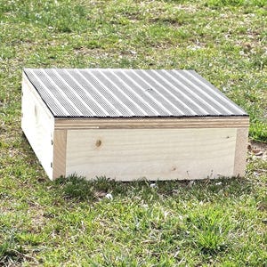 May include: A wooden step with a black rubber top. The step is made of natural wood and has a simple design.