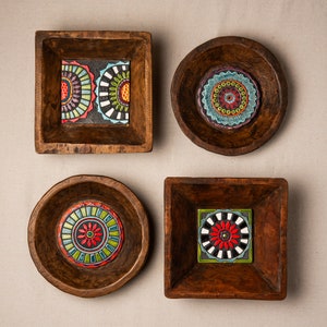May include: Four wooden bowls with colorful tile inlays. Each bowl features a different geometric design with red, blue, green, and white colors.