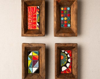 May include: Four wooden trays with colourful tile inlays. The tiles feature geometric patterns in red, blue, green, yellow, and white. The trays are perfect for displaying small items or serving snacks.