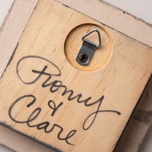 May include: A wooden plaque with a metal hanging hook on the back. The plaque is signed "From my Clare".