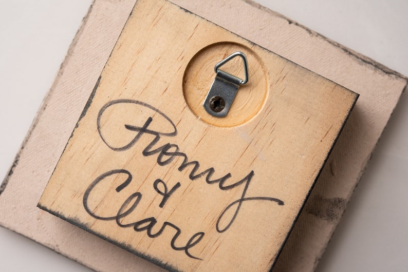 May include: A wooden plaque with a metal hanging hook on the back. The plaque is signed "From my Clare".