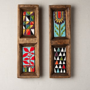Könnte beinhalten: Zwei Holz-Serviertabletts mit jeweils drei Fächern. Die Tabletts sind braun und haben bunte Keramikfliesen mit geometrischen und floralen Mustern.
