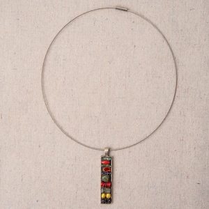 Puede incluir: Un collar de plata con un colgante hecho de azulejos de mosaico de colores. El colgante es rectangular y presenta azulejos rojos, verdes, amarillos y negros.