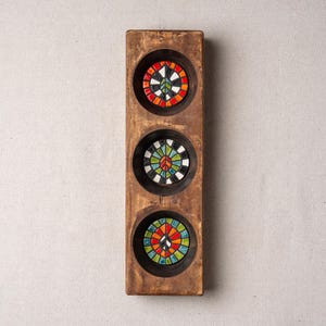 May include: A rectangular wooden wall plaque featuring three circular indentations, each containing a mosaic peace sign. The mosaics are composed of small, multi-colored glass tiles in shades of red, orange, yellow, green, blue, and white.