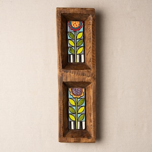 May include: A wooden serving tray with two compartments, each featuring a colorful floral design. The tray is brown and has a rustic look.