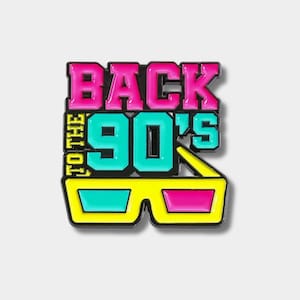 Puede incluir: Un colorido pin de esmalte con el texto "BACK TO THE 90'S". El pin presenta un diseño retro con colores rosa, turquesa y amarillo, y unas gafas 3D.