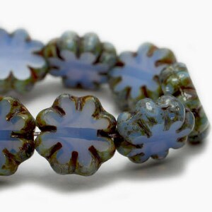 May include: A strand of light blue glass beads with a flower shape and a mottled green and brown glaze.
