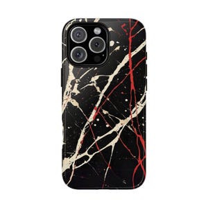 May include: Black phone case with a white and red splatter paint design.