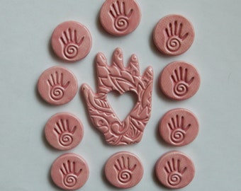 miami pink...handmade embossed earthenware ceramic mosaic tiles...one hand with a heart cut out and 10 hand clay coins