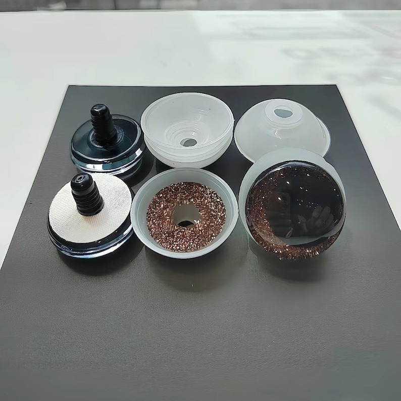 May include: A set of six craft eyes featuring a black pupil and a brown glitter iris. The components include three black plastic backs with threaded stems, two translucent white plastic washers, and one assembled eye with a clear dome cover.