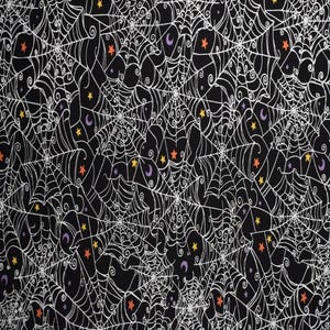 May include: Black fabric with a repeating pattern of white spiderwebs, orange stars, yellow stars, and purple crescent moons. The Halloween-themed design is suitable for various craft projects.