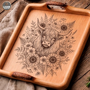 May include: Wooden serving tray with a laser-etched design of a Highland cow surrounded by sunflowers and other floral elements. The tray has carved handles and a natural wood finish. The logo "LASER BUILD.LAB" is in the upper left corner.