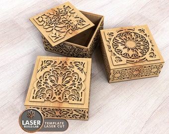 May include: Three wooden boxes with intricate laser cut floral designs. The boxes are closed and have a natural wood finish.