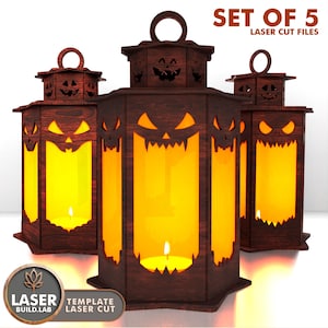 May include: Set of 5 laser cut wooden Halloween lanterns. Each lantern has a carved jack-o'-lantern face design with a handle on top. The lanterns are lit from within, casting a warm orange glow. The text "SET OF 5 LASER CUT FILES" is visible.