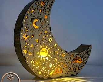 May include: A wooden crescent moon shaped nightlight with a laser cut design of stars, a sun, and a crescent moon. The nightlight is illuminated from within, casting a warm glow.