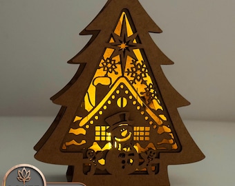 May include: A wooden Christmas tree cutout with a light inside. The tree has a gingerbread house and snowman design with snowflakes and a star.