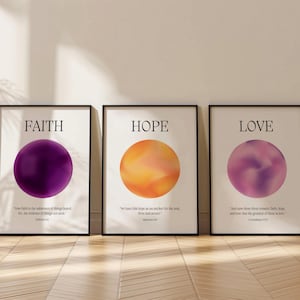 May include: Three framed prints with the words "FAITH", "HOPE", and "LOVE" in black text. Each print features a circle with a gradient of purple, orange, and pink. The prints are on a light wood floor.