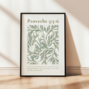 May include: A black framed print with a white background and a green leafy pattern. The text "Proverbs 3:5-6" is at the top of the print. The text "Trust in the Lord with all your heart and lean not on your own understanding; in all your ways submit to him, and he will make your paths straight." is at the bottom of the print.