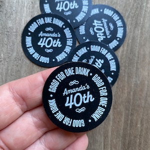 May include: Black and white round drink coasters with the text "Good for one drink" and "Amanda's 40th" printed on them.