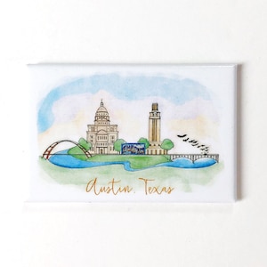 May include: A watercolor illustration of the Austin, Texas skyline featuring the Texas State Capitol building and the University of Texas Tower. The illustration is set against a blue sky with white clouds and a green river.