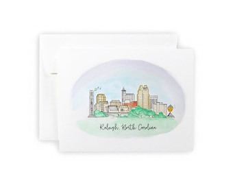 May include: Watercolor illustration of the Raleigh, North Carolina skyline with a light blue, purple, and green background. The illustration features a cityscape with buildings, a bridge, and trees.
