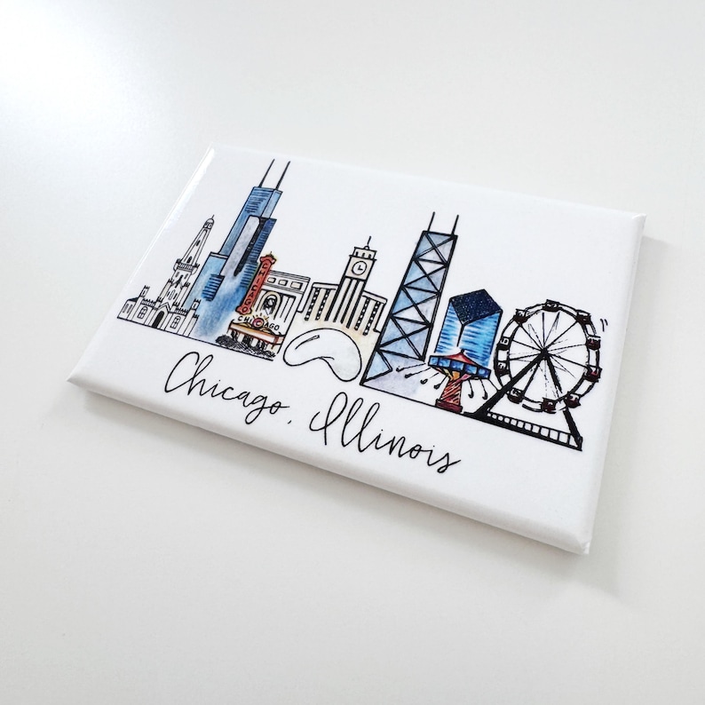 May include: A white magnet with a black and white illustration of the Chicago skyline. The skyline includes the Willis Tower, the John Hancock Center, the Wrigley Building, and the Navy Pier Ferris wheel. The text "Chicago, Illinois" is written below the skyline.
