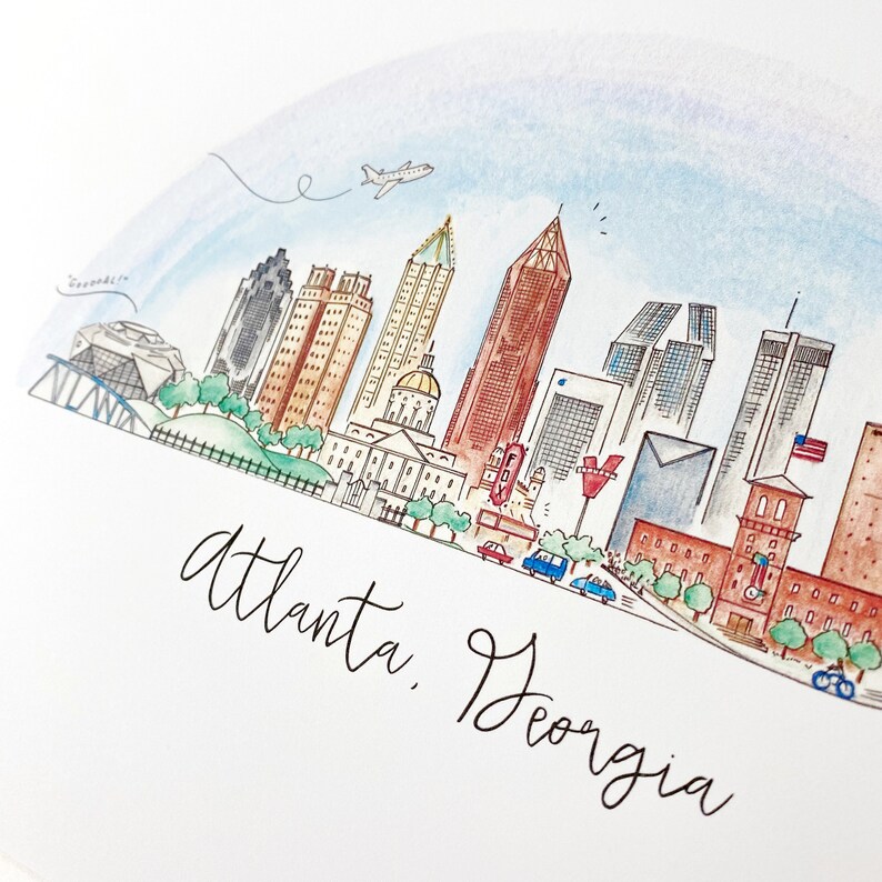 Pode incluir: Uma ilustra&ccedil;&atilde;o de aquarela do horizonte de Atlanta, Ge&oacute;rgia. A ilustra&ccedil;&atilde;o apresenta v&aacute;rios edif&iacute;cios, incluindo o edif&iacute;cio do Capit&oacute;lio do Estado, o World of Coca-Cola e o Aqu&aacute;rio da Ge&oacute;rgia. A ilustra&ccedil;&atilde;o tamb&eacute;m inclui um avi&atilde;o voando por cima, carros dirigindo na rua e &aacute;rvores.