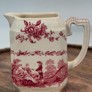 This small pitcher is a charming example of early English craftsmanship. Produced in the early 20th century. This is in the Watteau pattern
