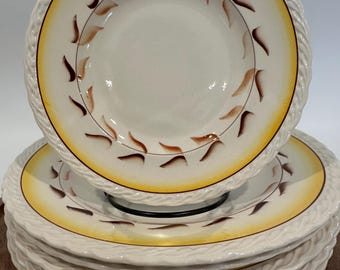 Puede incluir: Un conjunto de seis tazones de sopa de cerámica blanca con un borde amarillo y marrón y un diseño de cuerda. Los tazones tienen un patrón de hojas marrones.