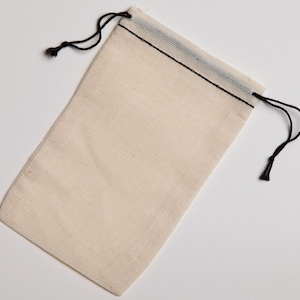 May include: A white cotton drawstring bag with black stitching and black drawstrings.