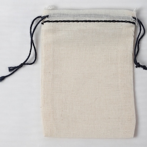 May include: A small, white drawstring bag made of a woven fabric with black drawstring ties.