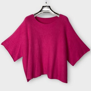 May include: A magenta short-sleeved sweater with a round neckline.