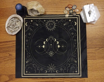 May include: Black and gold tapestry with a celestial design featuring a sun, moon phases, stars, and clouds. The text "Sacred Journey" is printed at the bottom.