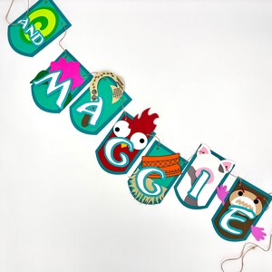 May include: A teal blue banner with the name "Maggie" spelled out in white letters. Each letter is decorated with a different character from the film Moana, including a rooster, a pig, and a crab.