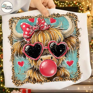 Peut inclure: Un coussin blanc avec une illustration fantaisiste d'une vache des Highlands. La vache porte des lunettes de soleil en forme de c&oelig;ur et un n&oelig;ud &agrave; pois. Elle a une bulle de chewing-gum et est entour&eacute;e de c&oelig;urs et d'une bordure l&eacute;opard.