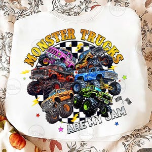 Peut inclure: Sweat-shirt blanc avec un motif color&eacute; de monster trucks. Le design pr&eacute;sente plusieurs camions violets, rouges, bleus, oranges et verts, avec le texte "MONSTER TRUCKS ARE MY JAM" dans un cercle.