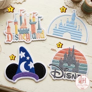 Könnte beinhalten: Vier gestickte Aufnäher mit ikonischen Schloss- und Hutmotiven. Der erste Aufnäher zeigt ein buntes Schloss mit dem Schriftzug Disneyland. Der zweite ist ein blauer Schlossumriss. Der dritte ist ein blauer Zaubererhut mit Ohren und der vierte ein Schloss.