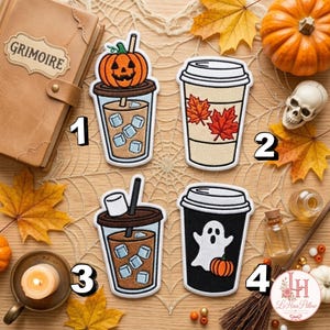 Puede incluir: Cuatro parches bordados con diseños de bebidas de temporada. El primero muestra un café helado con una calabaza de Halloween. El segundo es un vaso beige con hojas de arce rojas. El tercero es un café helado con un malvavisco. El cuarto es un vaso negro con un fantasma blanco y una calabaza naranja.