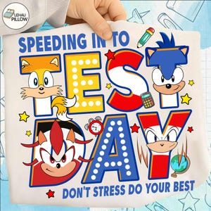 May include: A white pillowcase with a colorful graphic featuring Sonic the Hedgehog characters and the text "SPEEDING INTO TEST DAY DON'T STRESS DO YOUR BEST". The design includes stars, a pencil, and a calculator.
