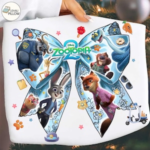 May include: White pillow featuring characters from the Disney movie Zootopia. The design includes Judy Hopps, Nick Wilde, and other characters arranged in a bow shape. The pillow has a light blue floral pattern and the movie title.
